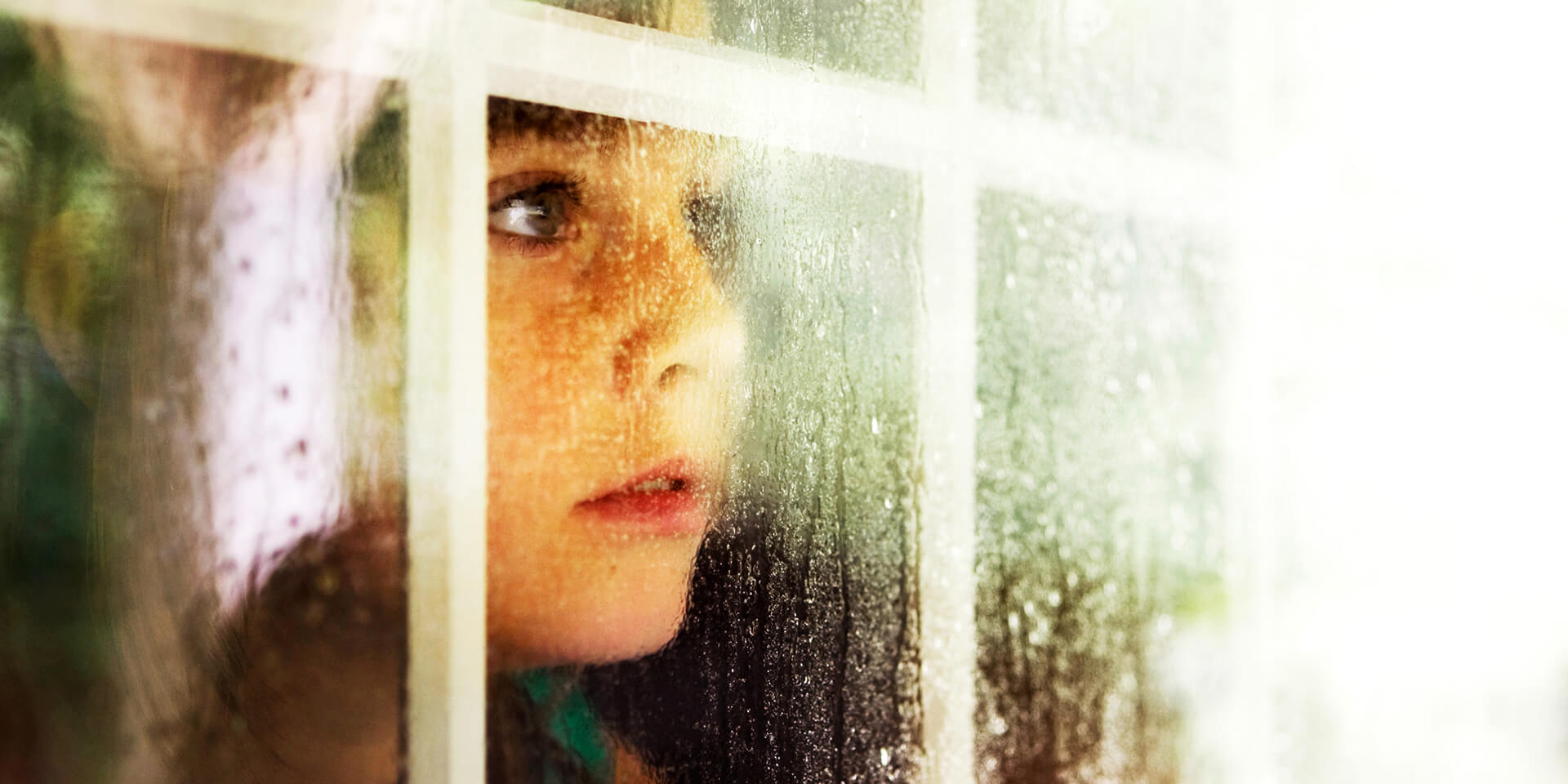 Kind an Fensterscheibe